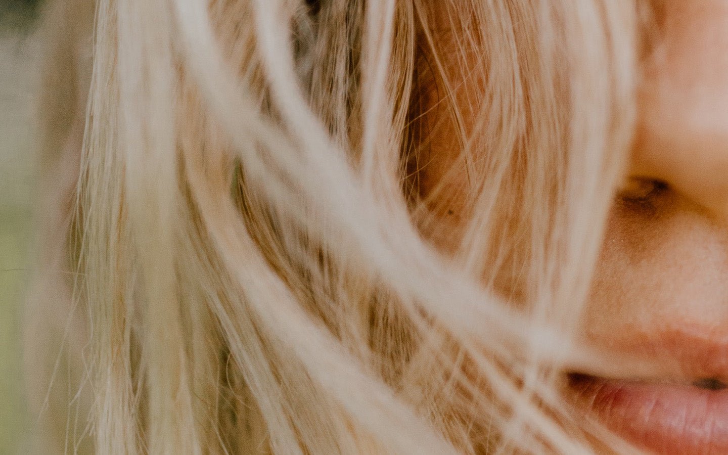 Close-up of a woman's blonde hair, cheek, and lips