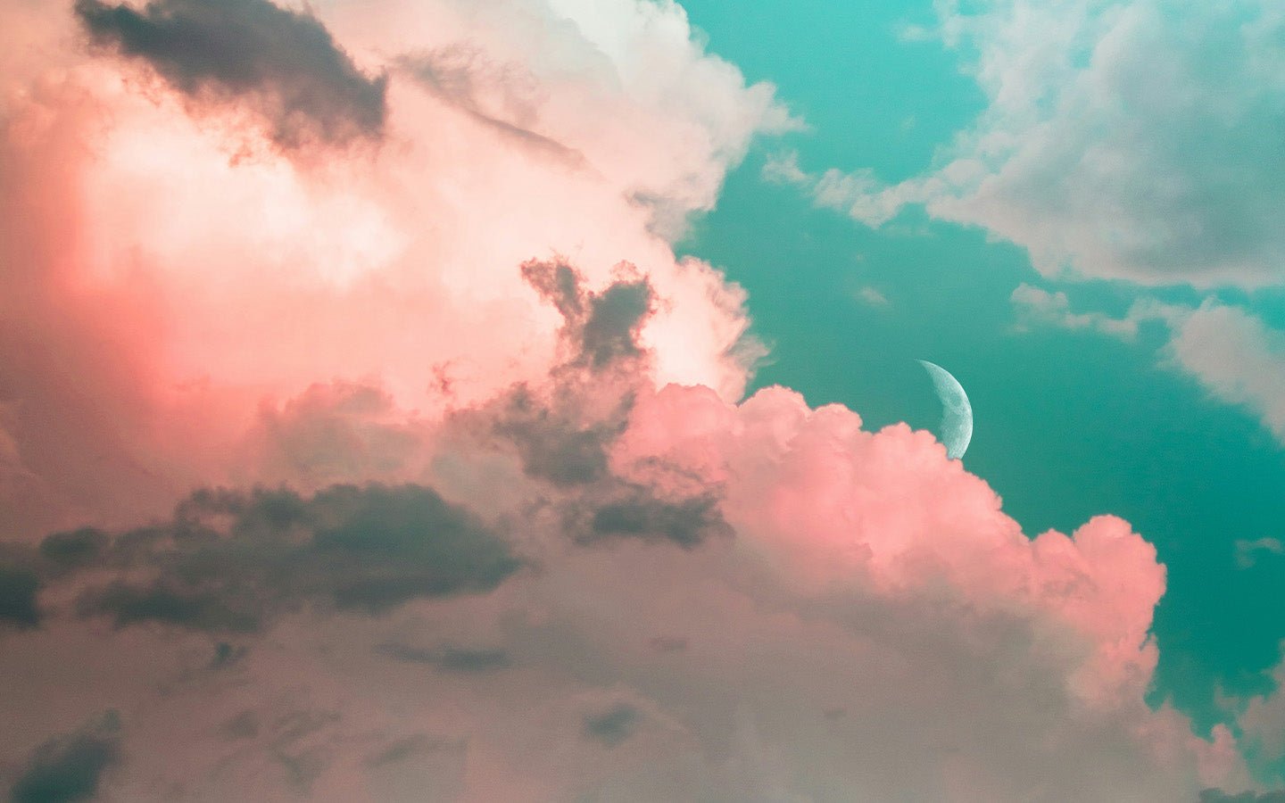 Pink and gray clouds in a teal sky with a crescent moon