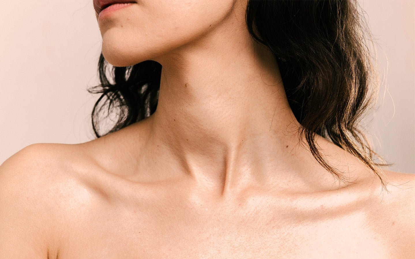 Close-up of a woman's neck and shoulders with dark hair