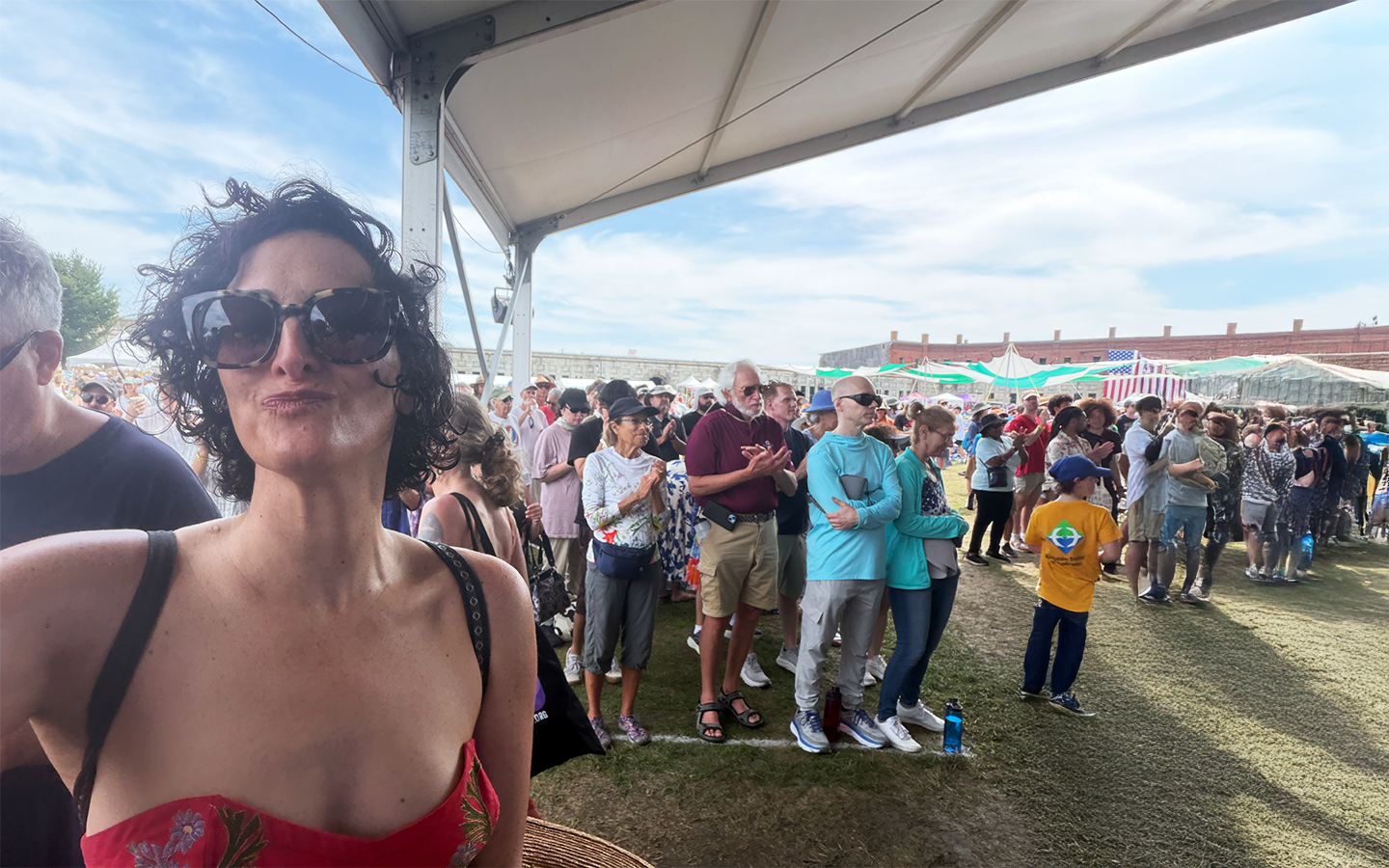 Dr. Catherine in the crowd at the Newport Jazz Festival at Fort Adams, tents and the fort wall behind her